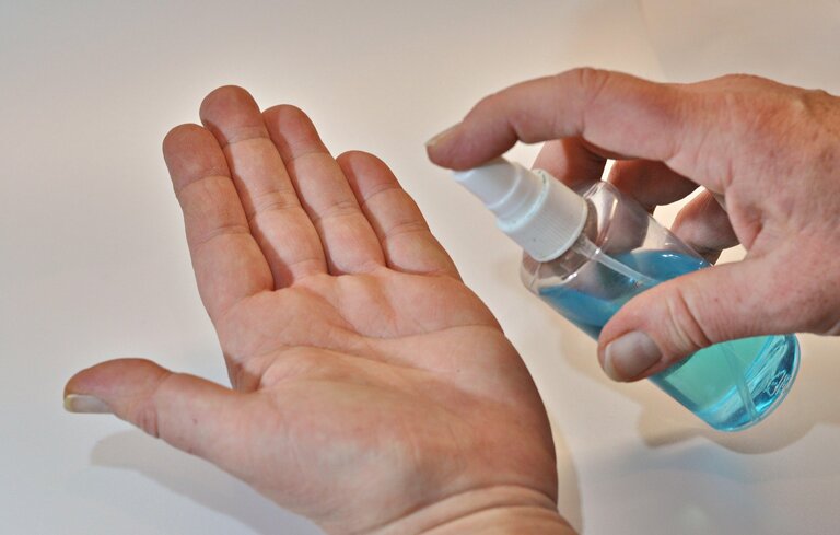 Disinfecting hands with spray