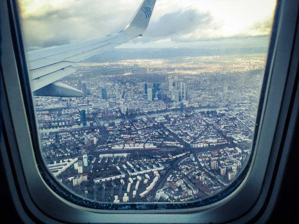 An aerial view of a city below from a plane’s window