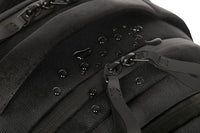 Close-up of a black backpack with zippers and straps on a white background