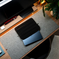 Black laptop case on a desk with a computer setup in the background