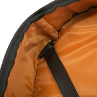 Close-up of an orange lining of backpack with a black zipper on a white background