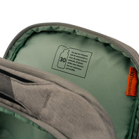 Close-up of the inside of a gray and sage green bag, showing a printed sustainability label on the lining and an orange side tag reading 'D30 Protected'