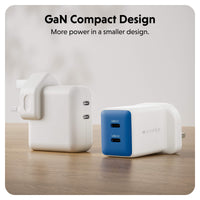 Two compact GaN chargers on a wooden surface with a soft blurred background. One charger is shown from the back in white, and the other is shown from the side in white with a blue front panel featuring two USB-C ports.