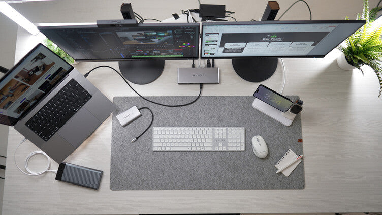 A photo of a home office with dual screens and a laptop