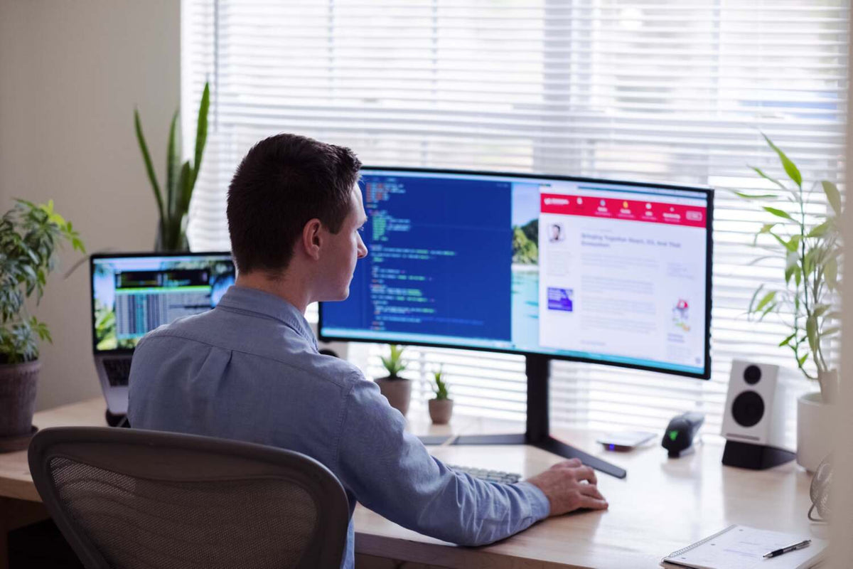 man working in front of computer monitor