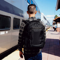 Man with a Targus black backpack standing on a train platform