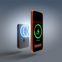 A portable wireless charger shown beside a smartphone with a glowing green charging icon and '75% Charged' text on a dark screen. The charger itself is matte gray with a blue circular light effect on the front, set against a smooth gray gradient background.